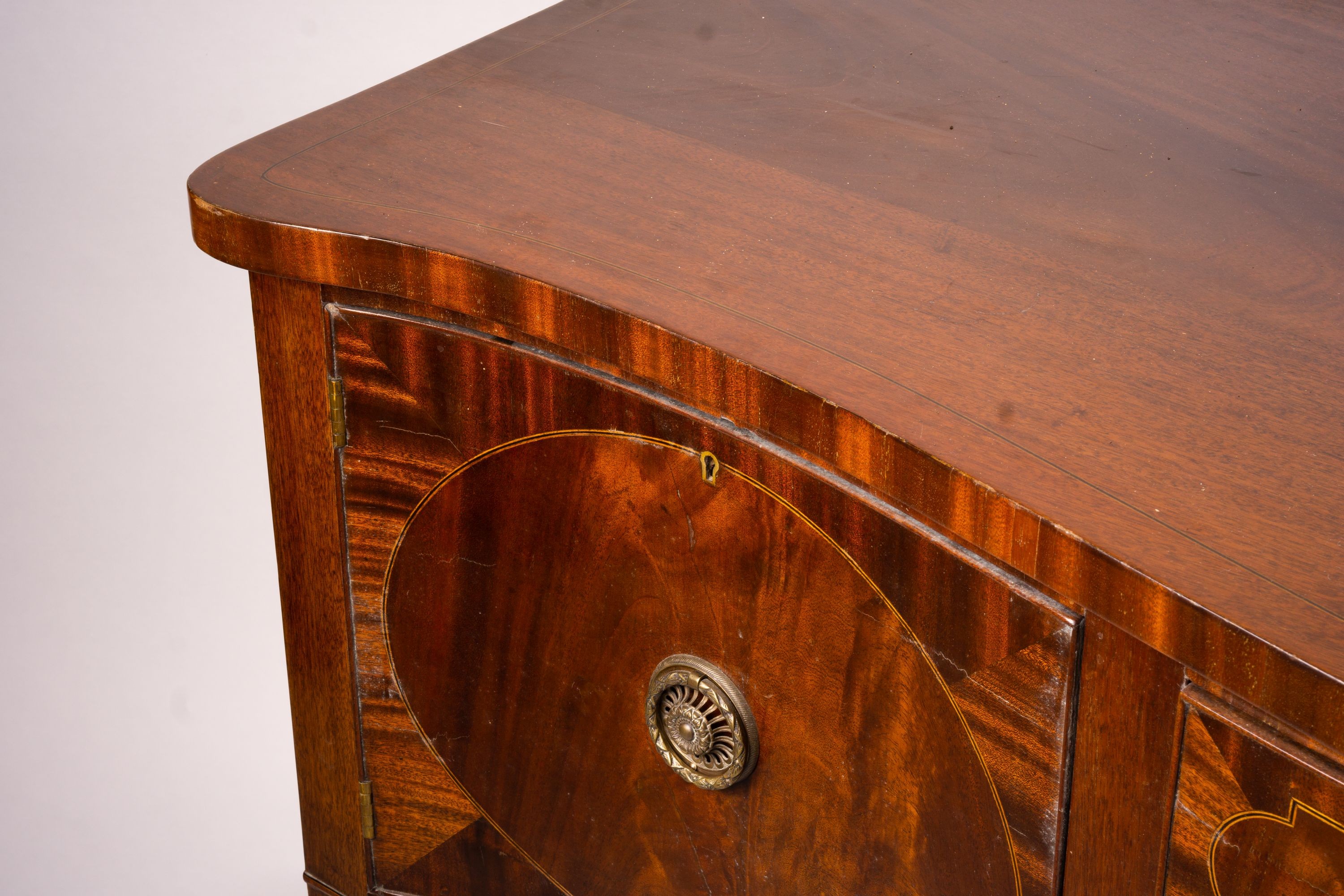 A George III style mahogany serpentine sideboard on square tapered legs, width 184cm, depth 63cm, height 93 cm